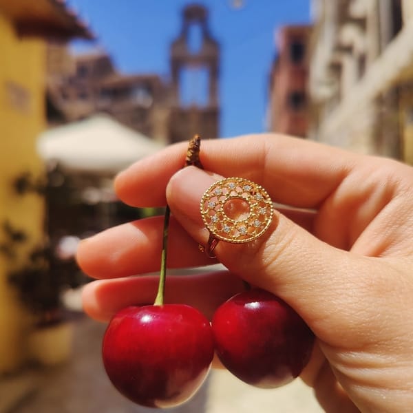 cicero jewelry silver gold-plated ring displayed with cherries in corfu old town